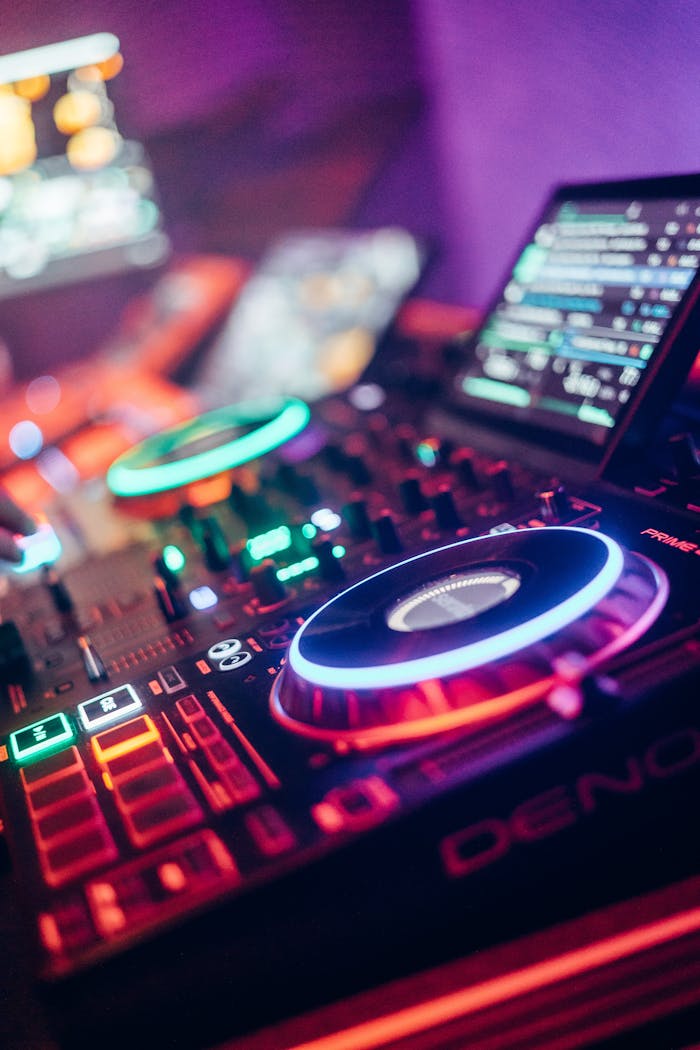 Home Colorful DJ equipment illuminated with neon lights in a lively nightclub setting.